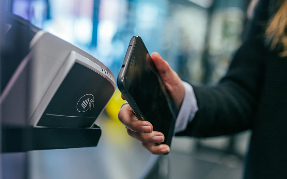 Customer using a contactless payment terminal, illustrating merchant stablecoin payment acceptance
