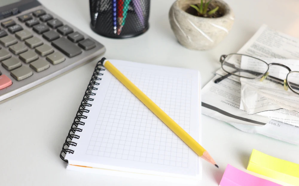 Calculator, notebook and glasses illustrating private credit underwriting and fund terms